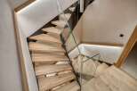 This stunning staircase is a true architectural marvel, featuring sleek glass railings and warm wooden steps.