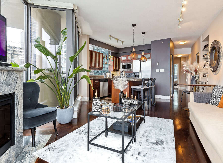 Experience luxury living in this stunning condo, featuring a modern kitchen with stainless steel appliances and a breakfast bar.
