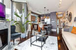 Experience luxury living in this stunning condo, featuring a modern kitchen with stainless steel appliances and a breakfast bar.