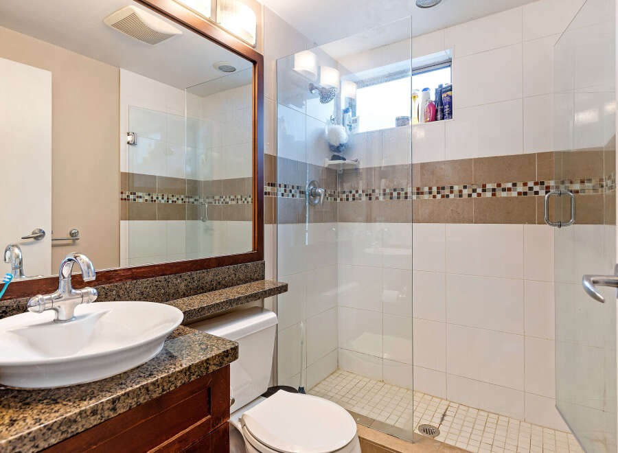 This bathroom features a modern design with a glass shower enclosure, offering a sleek and spacious feel.