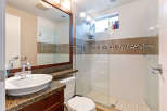 This bathroom features a modern design with a glass shower enclosure, offering a sleek and spacious feel.