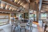 Experience luxury living in this stunning chalet, featuring a spacious dining area with a modern round table and stylish chairs.