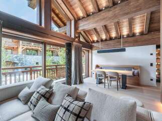 This stunning property boasts a luxurious interior with exposed wooden beams and expansive windows that flood the space with natural light.