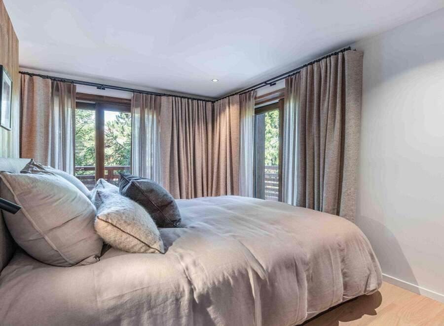 This cozy bedroom features a comfortable bed with plush pillows and a neutral-toned duvet, creating a relaxing atmosphere.