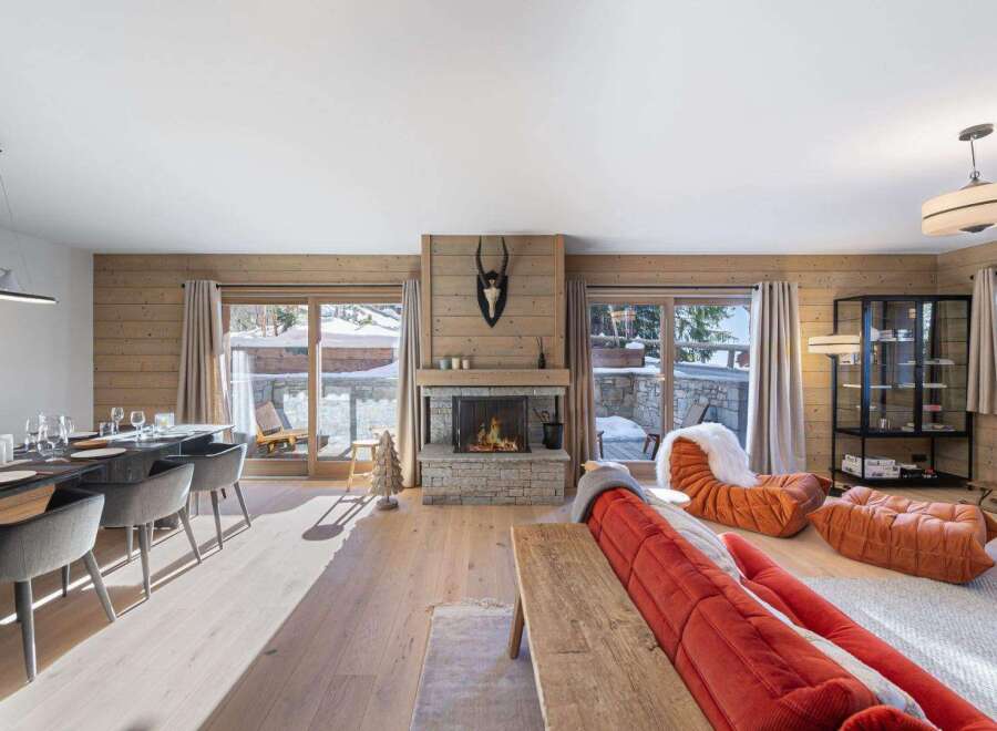 Experience the epitome of luxury living in this stunning property, featuring a cozy fireplace and expansive windows that frame breathtaking snowy views.
