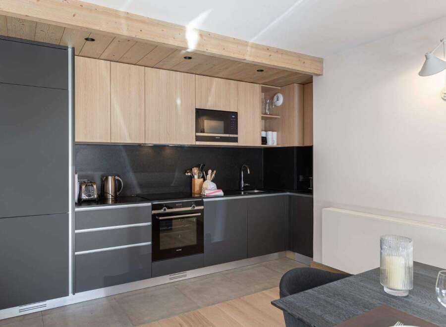This modern kitchen features sleek cabinetry, a built-in microwave, and a stylish backsplash.