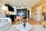Experience modern living in this stylish apartment featuring a sleek black kitchen and a cozy dining area.