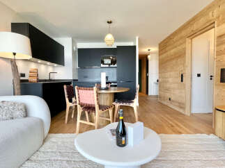 Experience modern living in this stylish apartment featuring a sleek black kitchen and a cozy dining area.