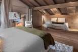 Experience luxury living in this stunning property, featuring a cozy bedroom with a plush bed and a stylish seating area.