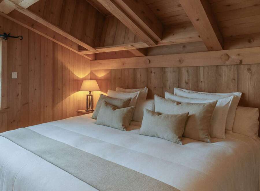 Experience rustic charm in this cozy bedroom, featuring warm wooden accents and a vaulted ceiling.