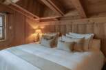 Experience rustic charm in this cozy bedroom, featuring warm wooden accents and a vaulted ceiling.
