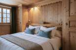 Experience the warmth and charm of this cozy bedroom, featuring exquisite wooden paneling that envelops the space.