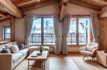 Experience the charm of this stunning property, featuring a cozy living room with exposed wooden beams and large windows offering breathtaking views.