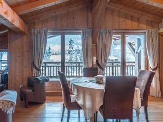 Experience the charm of this stunning property, featuring a cozy dining area with a round table and comfortable chairs.