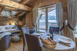 Experience the charm of this stunning chalet, boasting a cozy dining area with a breathtaking view.