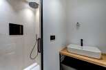 This modern bathroom features a sleek shower with a rainfall showerhead and a stylish sink.