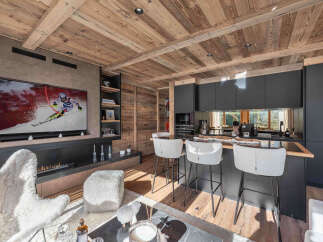 Experience luxury living in this stunning chalet, featuring a cozy living area with a fireplace and a large TV perfect for entertaining.