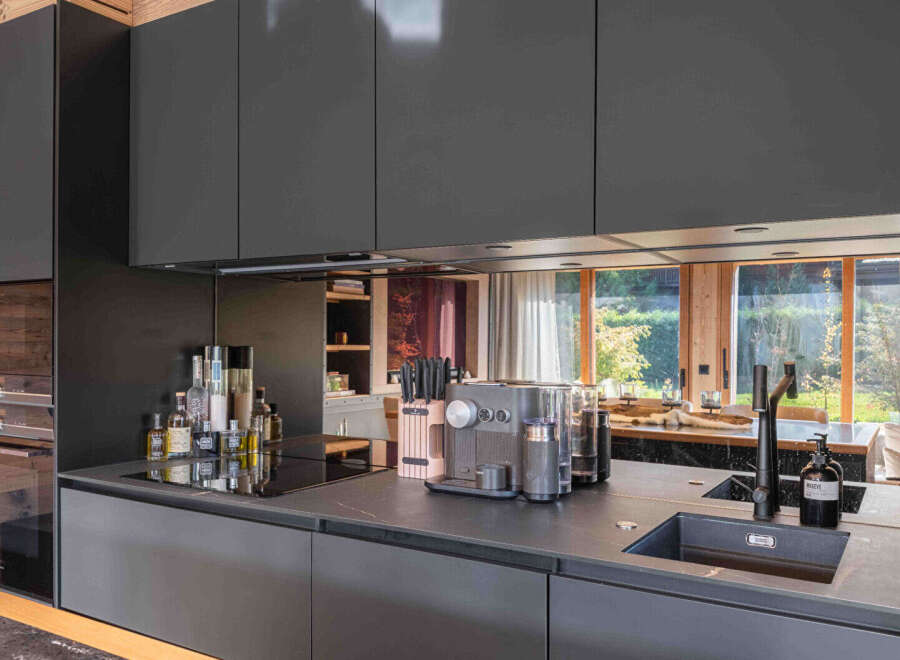 This modern kitchen boasts sleek, dark cabinetry and a minimalist design, perfect for contemporary living.