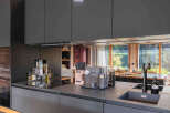 This modern kitchen boasts sleek, dark cabinetry and a minimalist design, perfect for contemporary living.