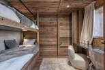 This cozy bedroom features custom-built bunk beds with a warm wooden aesthetic, perfect for a mountain retreat.