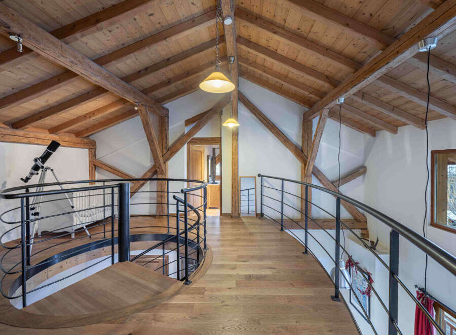 This stunning property boasts a unique architectural design with exposed wooden beams and a charming spiral staircase.