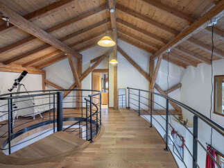 This stunning property boasts a unique architectural design with exposed wooden beams and a charming spiral staircase.