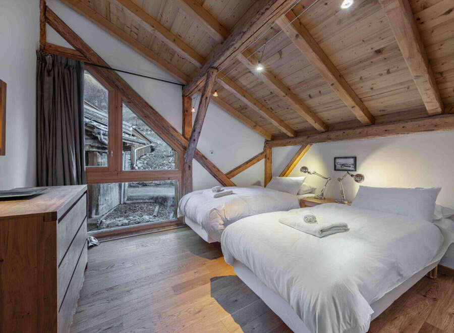Experience the charm of this stunning bedroom, featuring exposed wooden beams and a cozy ambiance.