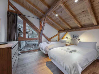 Experience the charm of this stunning bedroom, featuring exposed wooden beams and a cozy ambiance.