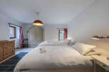This charming bedroom features two comfortable beds with crisp white linens, perfect for a relaxing stay.