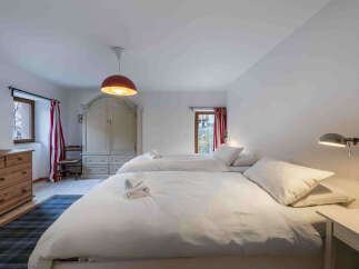 This charming bedroom features two comfortable beds with crisp white linens, perfect for a relaxing stay.