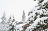 Nestled in a serene winter wonderland, this property offers stunning views of a snow-covered village and a charming church steeple.