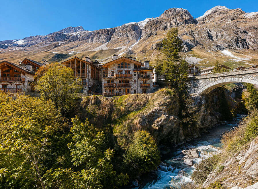 Experience luxury mountain living in this stunning alpine village featuring charming stone and wood chalets.