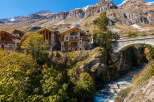 Experience luxury mountain living in this stunning alpine village featuring charming stone and wood chalets.