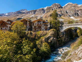 Experience luxury mountain living in this stunning alpine village featuring charming stone and wood chalets.