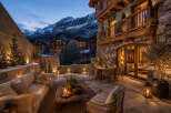 Experience luxury mountain living with this stunning chalet featuring a spacious outdoor patio, perfect for enjoying the crisp evening air.