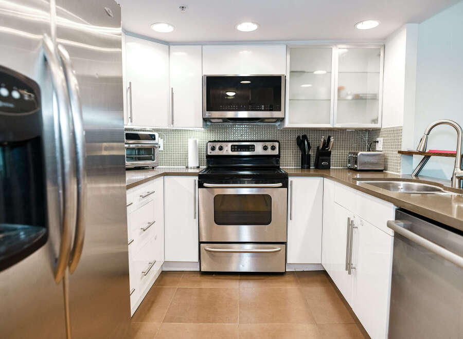 This modern kitchen boasts sleek stainless steel appliances, including a refrigerator, oven, and dishwasher.