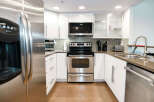This modern kitchen boasts sleek stainless steel appliances, including a refrigerator, oven, and dishwasher.