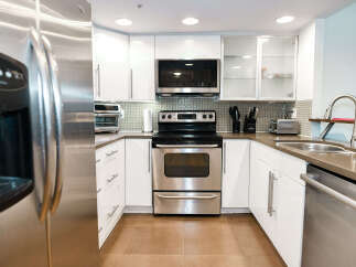 This modern kitchen boasts sleek stainless steel appliances, including a refrigerator, oven, and dishwasher.