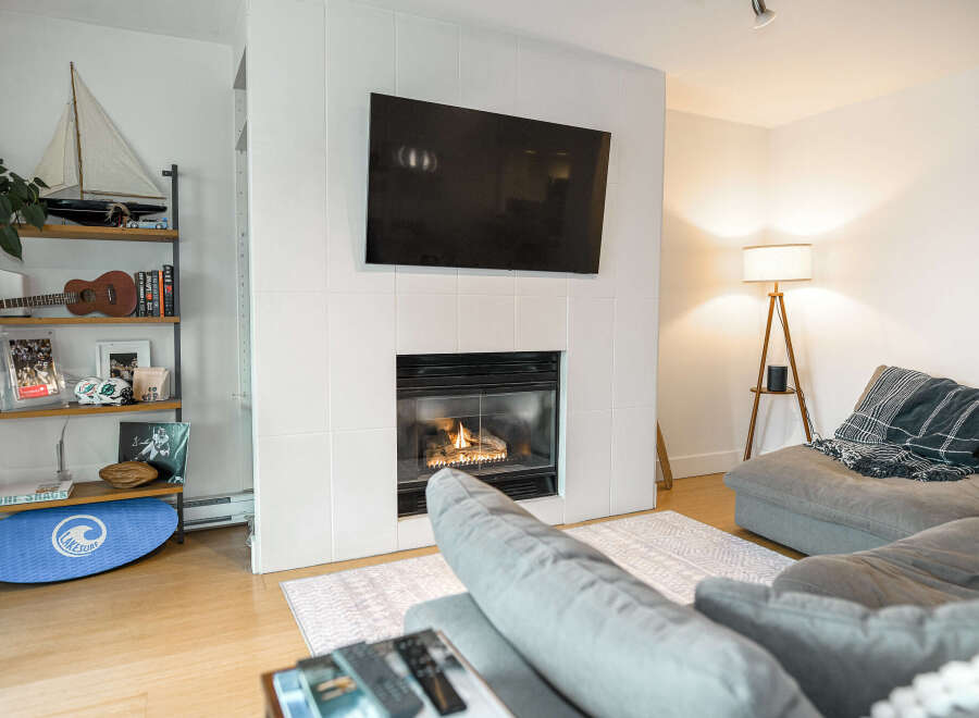 This cozy living room features a modern fireplace with a mounted TV, perfect for relaxing evenings.