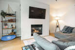 This cozy living room features a modern fireplace with a mounted TV, perfect for relaxing evenings.