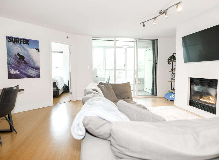 This stunning condo boasts a modern living space with a cozy fireplace and a sleek, mounted TV.