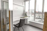This modern home office features a sleek, minimalist design with a built-in desk and ample natural light.