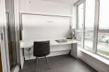 This modern condo features a stylish Murphy bed that doubles as a desk, perfect for maximizing space.