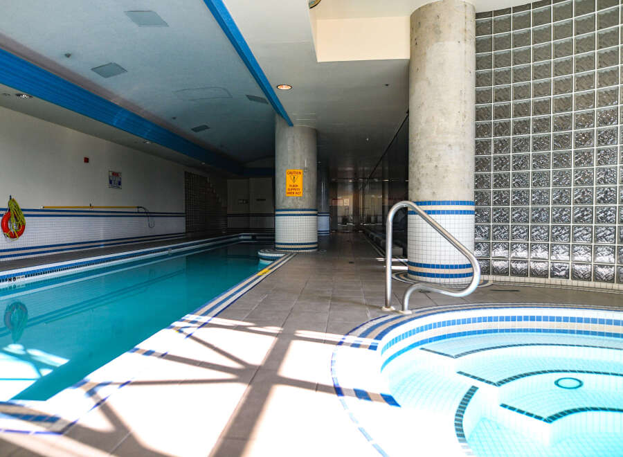 This stunning indoor pool area features a luxurious design with a long, inviting pool and a relaxing jacuzzi.