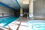 This stunning indoor pool area features a luxurious design with a long, inviting pool and a relaxing jacuzzi.