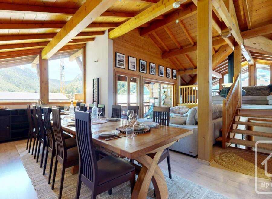 Experience luxury living in this stunning property featuring a spacious dining area with a large wooden table, perfect for gatherings.