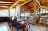 Experience luxury living in this stunning property featuring a spacious dining area with a large wooden table, perfect for gatherings.