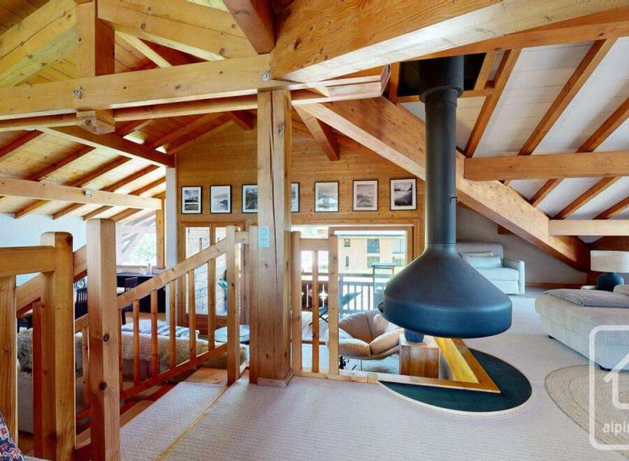 This stunning property boasts a unique architectural design with exposed wooden beams and a cozy fireplace, creating a warm and inviting atmosphere.