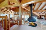 This stunning property boasts a unique architectural design with exposed wooden beams and a cozy fireplace, creating a warm and inviting atmosphere.