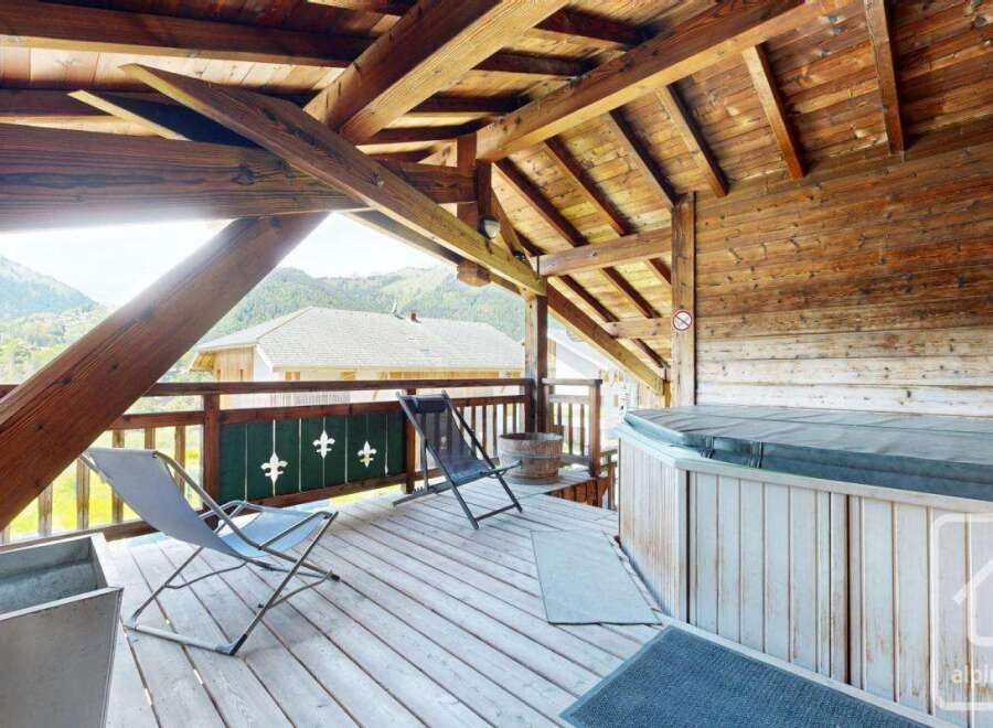 Enjoy breathtaking mountain views from this stunning property featuring a private hot tub and a spacious wooden deck.